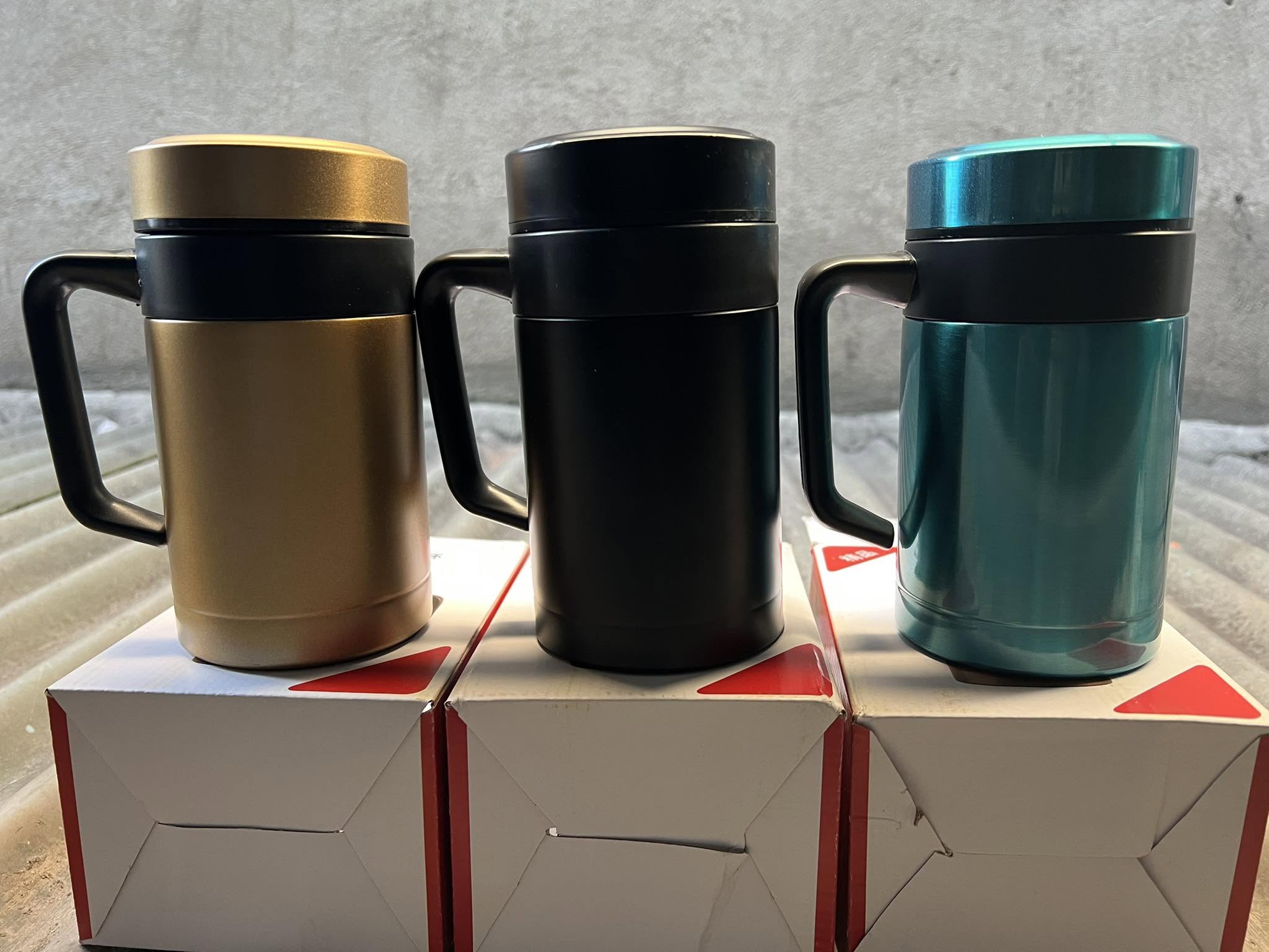 Insulated travel mugs in gold, black and teal